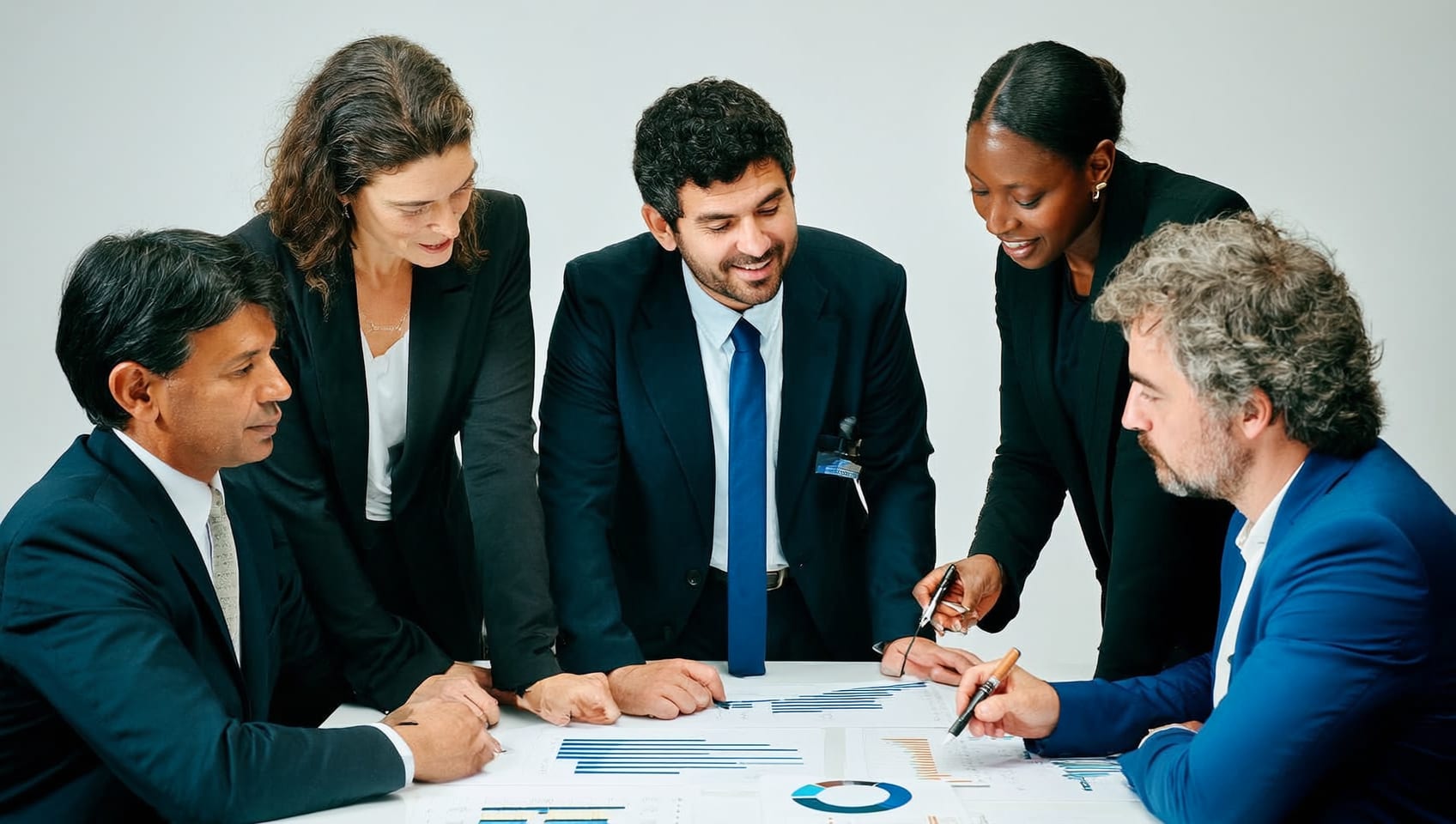 A JULY Commercial advisory team briefing each other around a table with market charts
