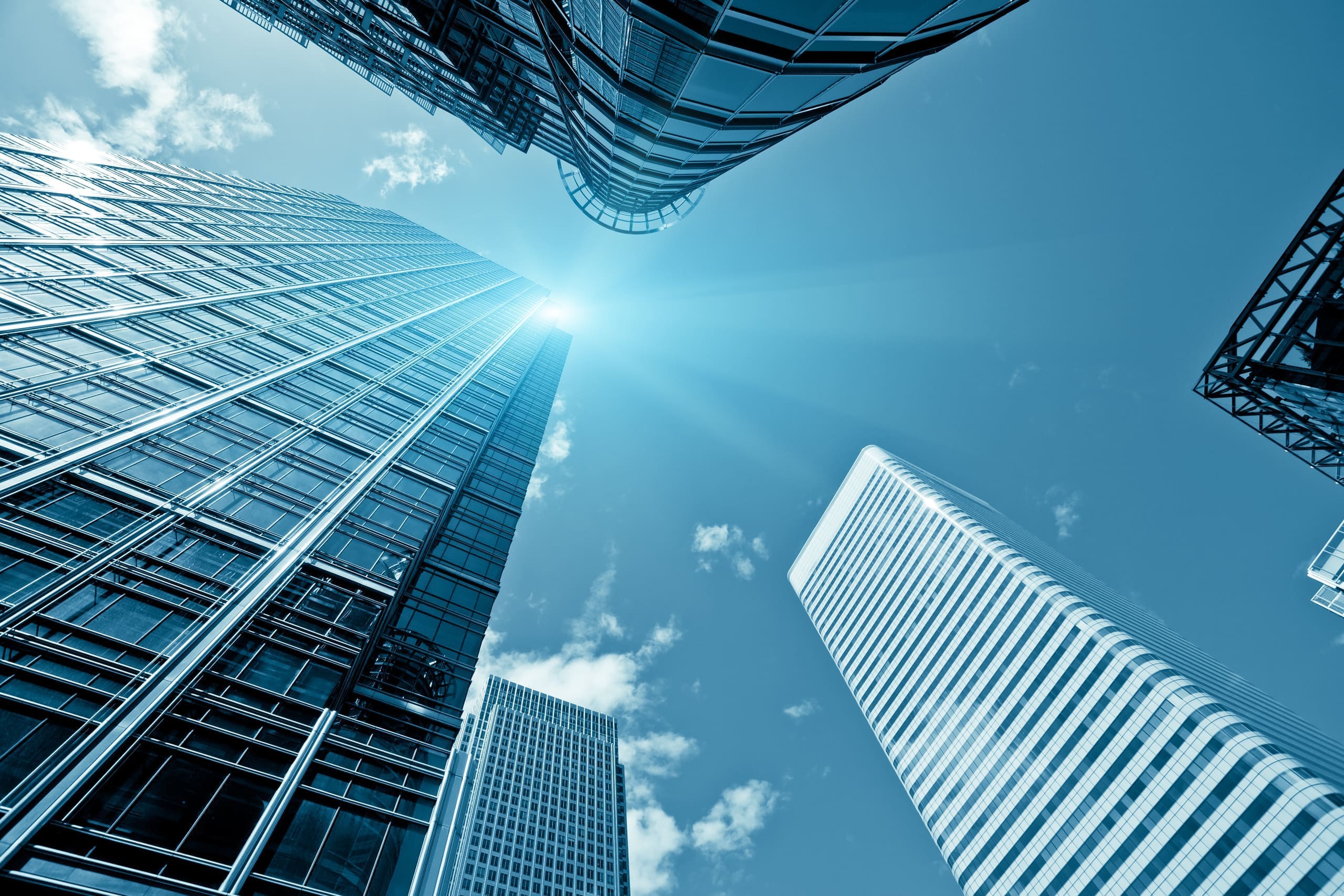 Glass office towers rising against a blue sky